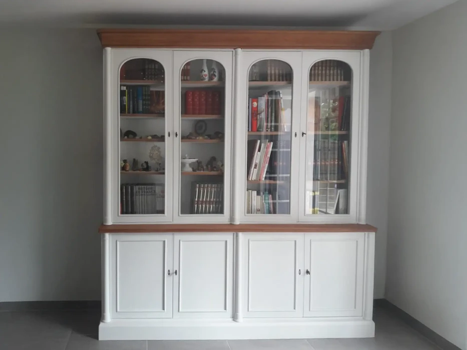 Intérieur résidentiel avec bibliothèque murale blanche à quatre portes vitrées supérieures et quatre portes pleines inférieures